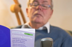 Photograph of a man reading the claiming benefits leaflet