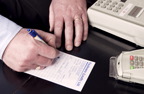 photograph of a man writing out a receipt